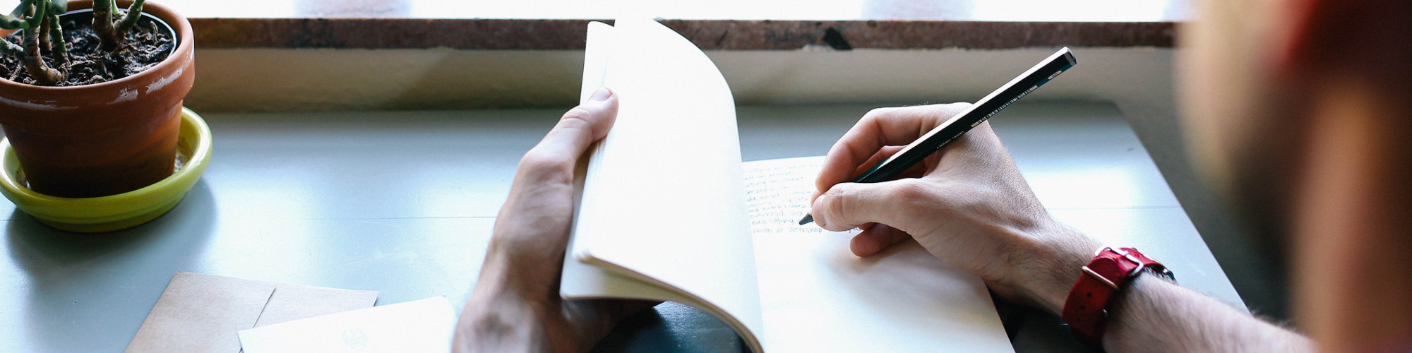 header image man writing in notebook